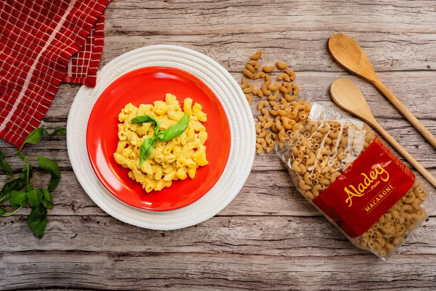 A plate of creamy Aladey Macaroni with basil, beside the 500 g pack