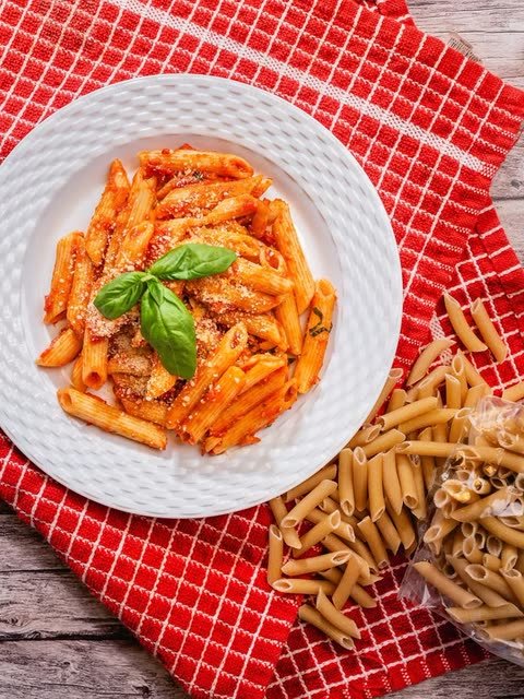 A plate of Aladey Penne in tomato sauce with basil